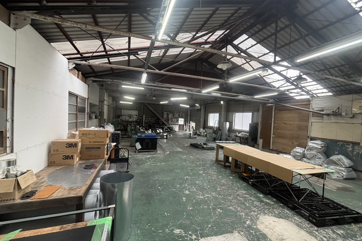 1階加工場の全景。板金加工用の機械や作業台、資材が並ぶ加工スペース